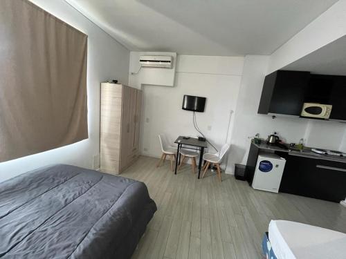1 dormitorio con 1 cama y 1 mesa con sillas en Mis Vacaciones en Buenos Aires
