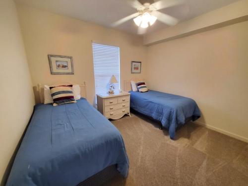 1 dormitorio con 2 camas y ventilador de techo en Seaside at Anastasia 306, en St. Augustine Beach