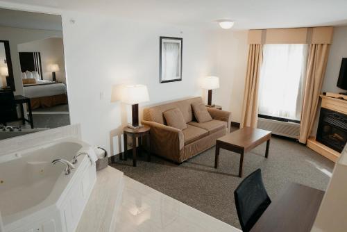 a living room with a tub and a couch in a hotel room at Ramada Golden in Golden