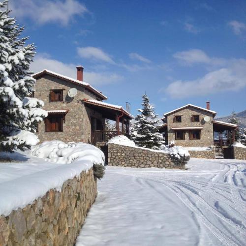 a stone house in the snow with a driveway at Mont Valley Boutique Chalets in Arachova