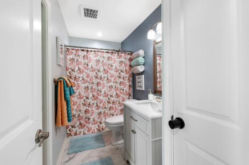 a bathroom with a toilet and a shower curtain at Minutes to Manasota Beach 2 King Beds Fenced yard Pets Welcome in Englewood