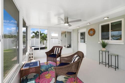 a porch with chairs and a table and windows at Minutes to Manasota Beach 2 King Beds Fenced yard Pets Welcome in Englewood