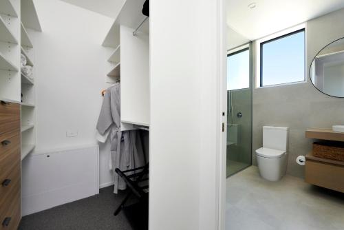 a bathroom with a toilet and a mirror at Harakeke Boutique Accommodation in Mahana