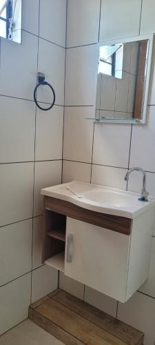 y baño con lavabo y espejo. en Kit net amplo en São Lourenço