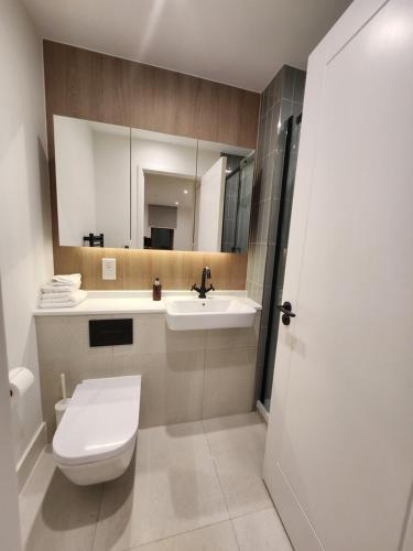 a bathroom with a toilet and a sink and a mirror at Stunning 2-Bed Apartment in Brentford in Brentford