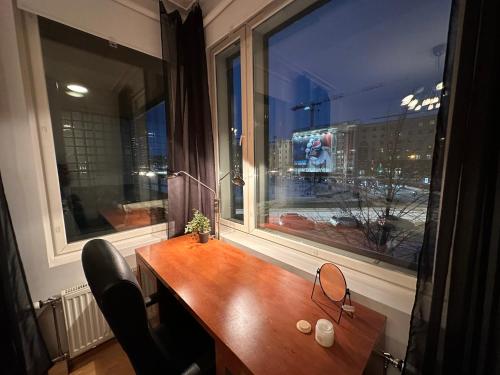 a desk in a window with a view of a city at Moderni huoneisto saunalla! Keskustan lähellä, Merenrannassa, loistava varustelu! in Helsinki