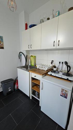 a small kitchen with white cabinets and a sink at Berlin Calling-Oase in top Lage in Berlin