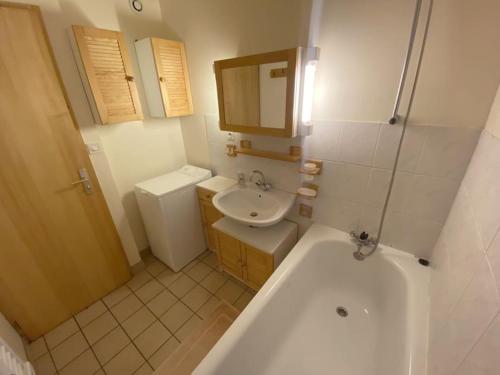 a bathroom with a tub and a sink and a toilet at Les chênes Rouges 4/p in Gérardmer