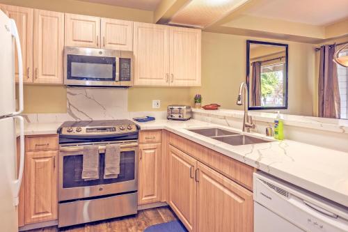 a kitchen with wooden cabinets and a sink and a microwave at Ko Olina Fairways #4E townhouse in Kapolei