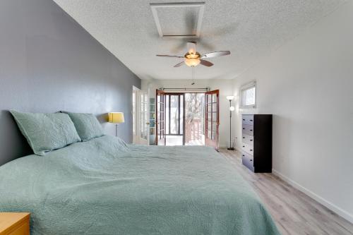 a bedroom with a green bed and a ceiling fan at Convenient Colorado Horse Farm Apt with Balcony! in Aurora