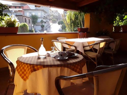 B&B Il Girasole في Laureana di Borrello: طاولتين وكراسي على شرفة مع نافذة