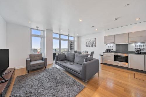 a living room with a couch and a kitchen at Great 2 Bed Flat With City View in London