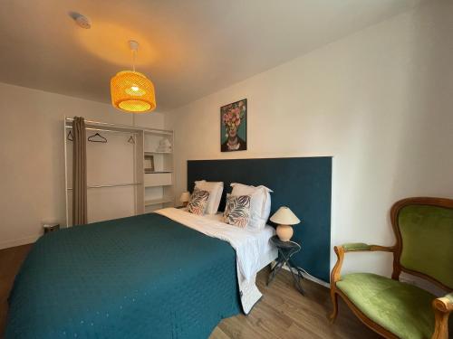 um quarto com uma cama grande e uma cadeira verde em Lady Cosmopolite em Arras
