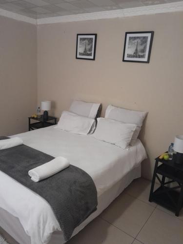 a bedroom with a bed with white sheets and pillows at SoftLife Capsule Hotel in Ulundi