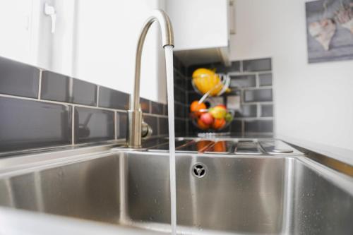a kitchen sink with a faucet and a bowl of fruit at Glasgow, Bothwell, 3 bed, Suitable for Long Stays in Bothwell