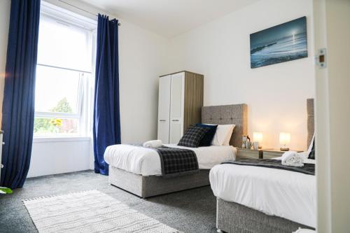 1 dormitorio con 2 camas y ventana en Glasgow, Bothwell, 3 bed, Suitable for Long Stays en Bothwell