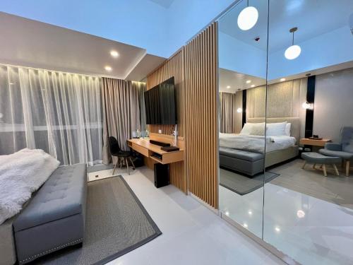 a bedroom with a bed and a desk at Hotel Vibe Condo at Uptown Parksuites BGC in Manila
