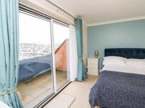 um quarto com uma cama e uma grande janela em Mountbatten House em Plymouth