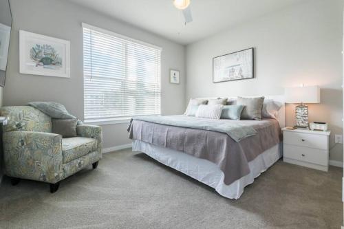 een slaapkamer met een bed, een stoel en een raam bij Amazing New Mayo King Suite 5* in Jacksonville