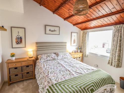 a bedroom with a bed and a window at Branwen in Porthmadog