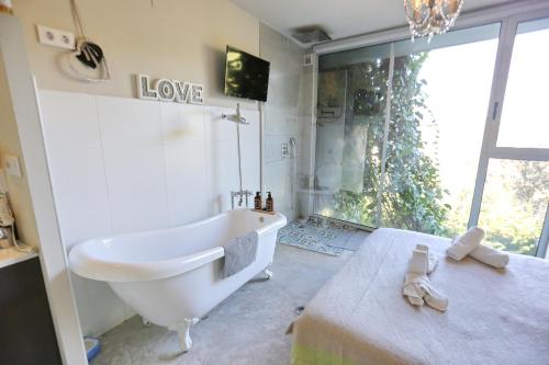 a bathroom with a white tub and a sink at Les Suites in Santa María de Palautordera