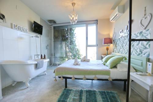 a bedroom with a tub and a bed and a bath tub at Les Suites in Santa María de Palautordera