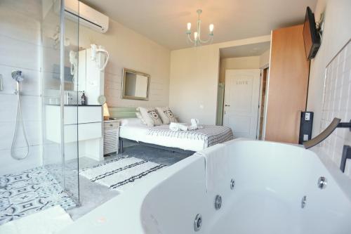a bathroom with a tub and a bed in a room at Les Suites in Santa María de Palautordera