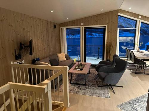 sala de estar con sofá, sillas y mesa en Malangen Arctic Sealodge Cabin 10, en Meistervik