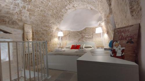 ein Schlafzimmer mit einem Bett und einer Steinmauer in der Unterkunft Cà Giò in Ostuni