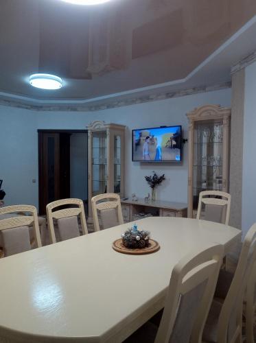una sala da pranzo con tavolo e sedie bianchi di MODEST a Slavske