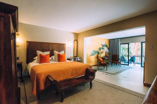 - une chambre avec un grand lit et un salon dans l'établissement The Bohemian Guesthouse, à Tzaneen