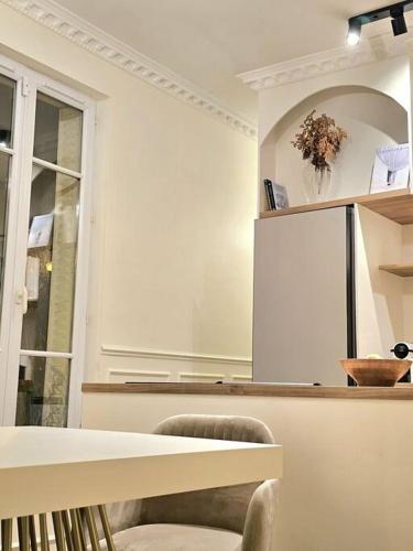 Cette chambre blanche dispose d'une table et d'une fenêtre. dans l'établissement Apartament JO2024, à Maisons-Laffitte