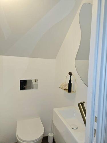 une salle de bain blanche avec des toilettes et un lavabo dans l'établissement Apartament JO2024, à Maisons-Laffitte