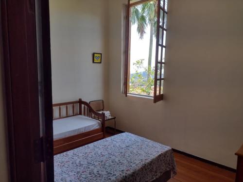 a room with two beds and a window at Casa rústica 2 em Santa Teresa in Rio de Janeiro