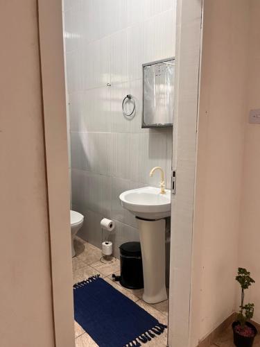 a bathroom with a sink and a toilet at Casa Bela in Praia Grande