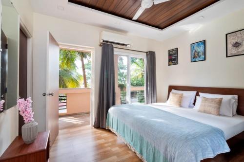 1 dormitorio con cama grande y ventana grande en 2bhk Aqua Grandiosa Near Baga beach, en Arpora