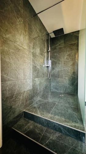 La salle de bains est pourvue d'une grande douche et d'une baignoire. dans l'établissement Appartement neuf au centre d'Épernay., à Épernay