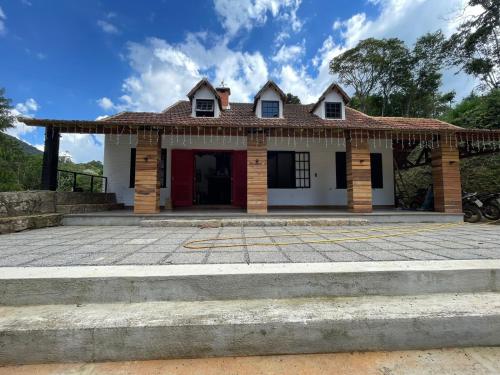 ein Haus mit einer roten Tür in der Unterkunft Pousada Motta in Miguel Pereira