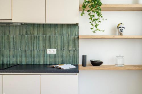 een keuken met witte kasten en een zwart aanrecht bij City Centre Apartment in Kortrijk