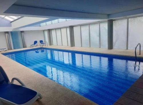 a large swimming pool with blue water in a building at Edificio Calypso - Primera línea al Mar in Punta del Este