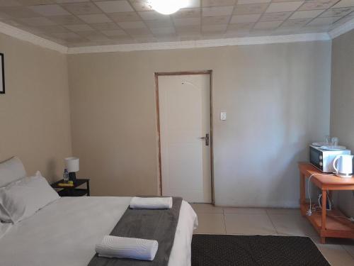 1 dormitorio con 1 cama y puerta a una habitación en SoftLife Capsule Hotel, en Ulundi