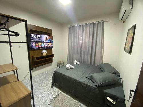 a bedroom with a bed and a tv in it at Quarto privativo no centro de Foz in Foz do Iguaçu