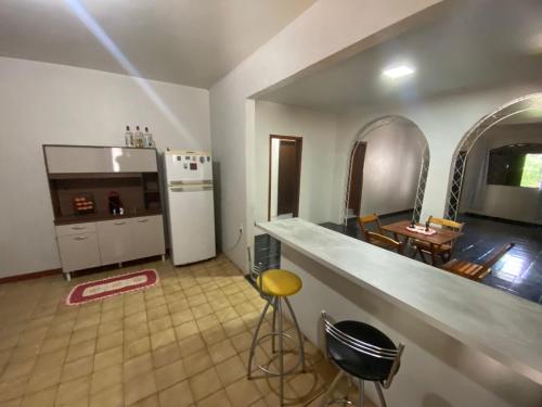 a kitchen with a counter and a kitchen with a refrigerator at Quarto privativo no centro de Foz in Foz do Iguaçu