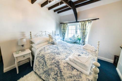 a bedroom with a large bed and a window at Boscastle Quaint Cornish Fishermans Cottage in Boscastle