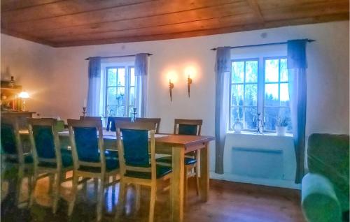 uma sala de jantar com uma mesa e cadeiras e duas janelas em 5 Bedroom Pet Friendly Home In Vallsta em Vallsta