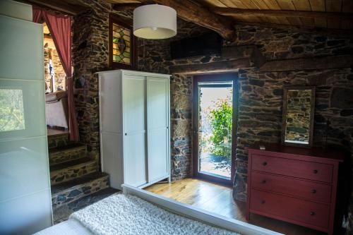 a bedroom with a red dresser and a window at Cabo Do Mundo Casa Rural in Chantada