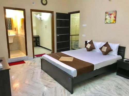 a bedroom with a large bed and a bathroom at NMA Holiday Inn in Jaffna