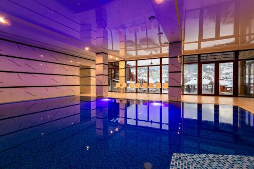 an empty swimming pool in a house with purple lighting at La Кrechunu in Bukovel
