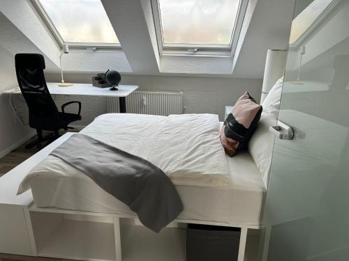 a bedroom with a bed with a window and a desk at Saarbrücken City Saar in Saarbrücken