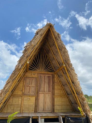 une maison au toit de chaume avec une grande porte dans l'établissement OCEAN BEACH, à Ríohacha